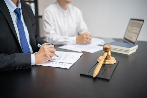 Legal Counsel präsentiert dem Mandanten einen unterschriebenen Vertrag mit Hammer und Legal Law Justice und Anwaltskonzept
