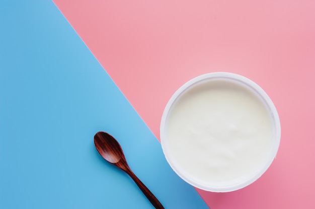 Legen Sie Joghurt mit natürlichem Geschmack und Holzlöffel