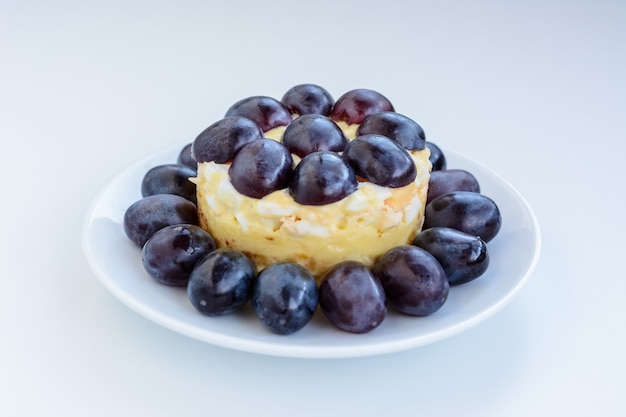 La legendaria ensalada de capas de Tiffany con uvas, pollo y queso sobre fondo blanco. Recibió su nombre del apodo de la señora que publicó la receta de la ensalada en el portal culinario.