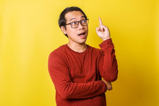 Legerer Mann in Brille mit Handgeste nach oben isoliert auf gelbem Hintergrund Ausdruck erhalten ID