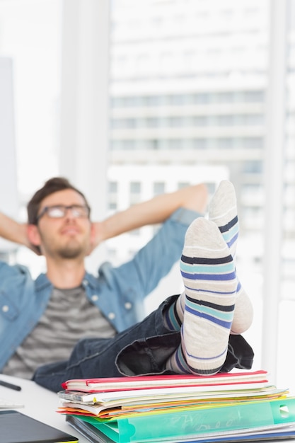 Legerer Mann mit Beinen auf Schreibtisch im Büro