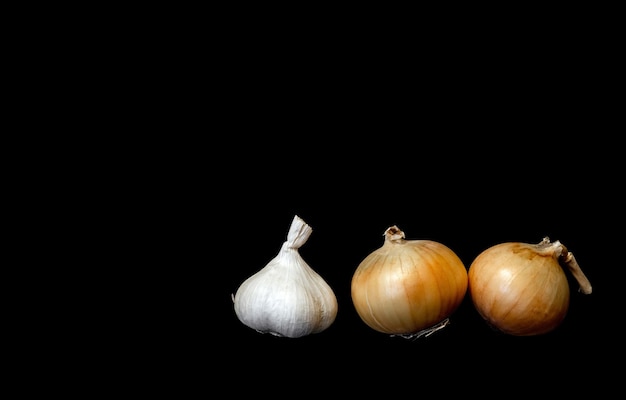 Legumes cebola e alho em fundo preto