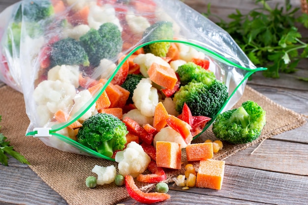 Legumes congelados em sacos plásticos em uma mesa Alimentos congelados