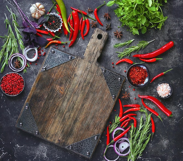 Legumes crus frescos e tábua vazia em fundo escuro