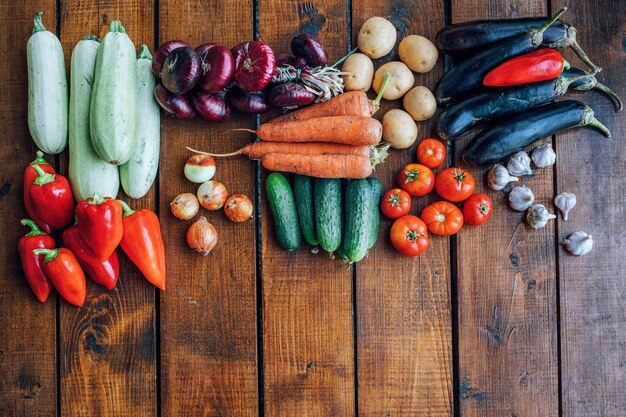 Legumes de diferentes cores em um fundo escuro texturizado com um lugar vazio para uma vista superior de inscrição.