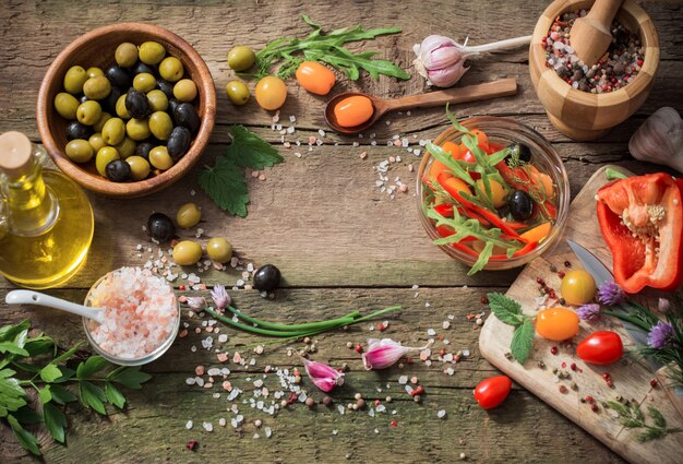 Legumes e azeitonas na mesa de madeira velha