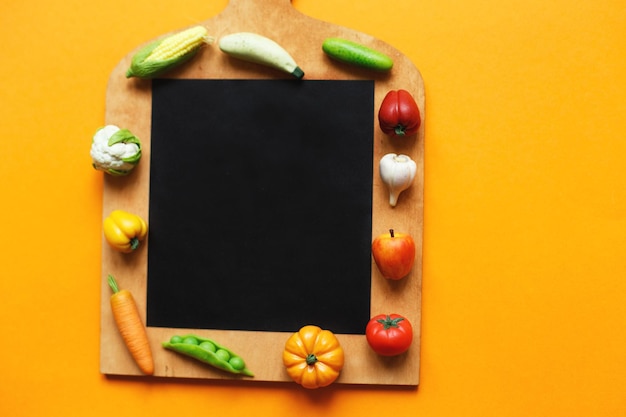 Legumes e frutas na tábua no conceito de cozinha saudável de fundo amarelo