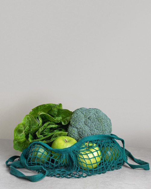 Legumes e frutas verdes em um avalka na mesa da cozinha sem embalagens de resíduos