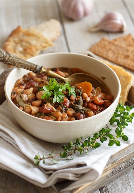 Legumes e vegetais cozidos em uma tigela na velha mesa de madeira