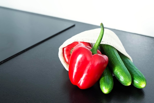 Legumes em uma grade na mesa da cozinha Pimenta búlgara e pepinos Grade para legumes