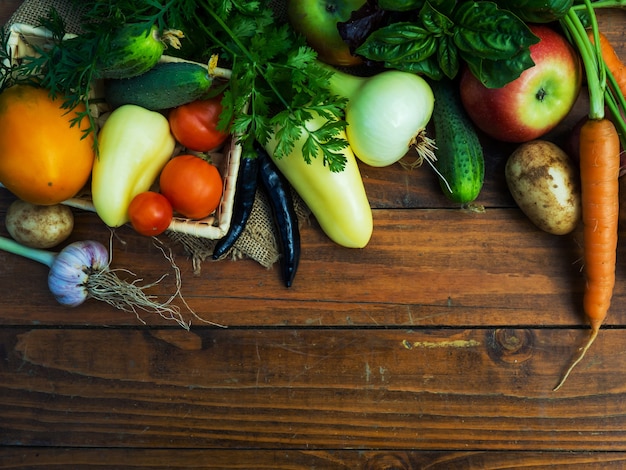 Legumes em uma mesa de madeira. Alimentos bio saudáveis, ervas e vegetais de plantações agrícolas.