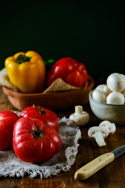 Legumes em uma mesa de madeira Legumes sazonais Tomates pimentas pepinos cogumelos em cima da mesa