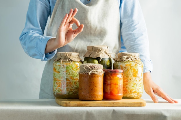 Foto legumes fermentados ou enlatados, diferentes cenouras de abobrinha, pepinos de chucrute em frascos ficam no sal contra