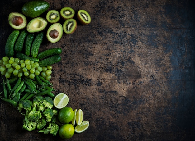 legumes frescos de jardim verdes e frutas em uma mesa de madeira