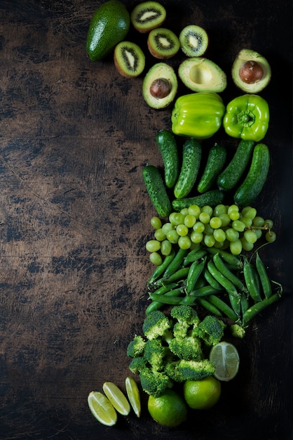 legumes frescos de jardim verdes e frutas em uma mesa de madeira