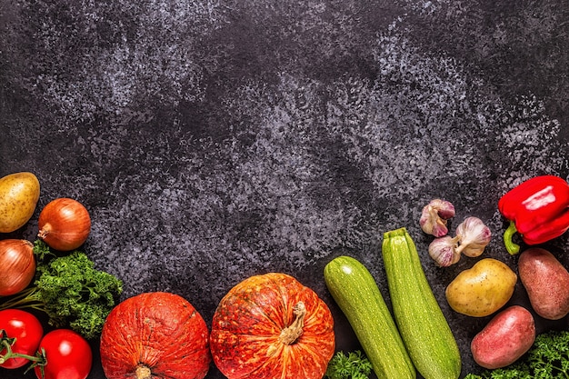 Legumes frescos de outono para cozinhar em um fundo escuro, vista superior.