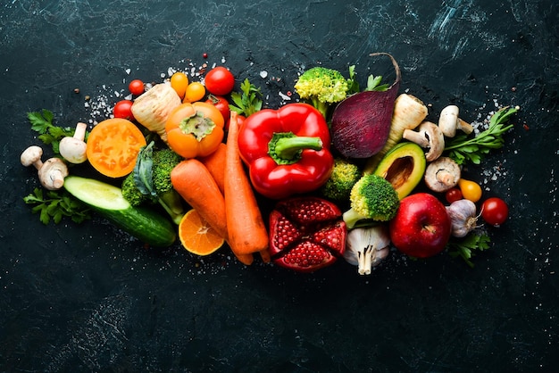 Legumes frescos e frutas no fundo de pedra preta Comida saudável Vista superior Espaço para cópia grátis