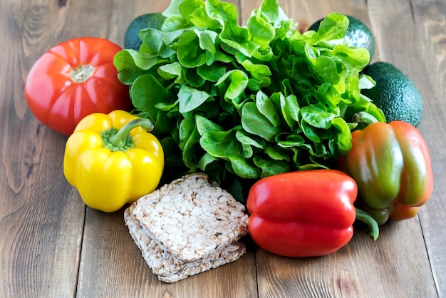 Legumes frescos em fundo de madeira Lindos pimentões amarelos e vermelhos crus Comida para dias de jejum