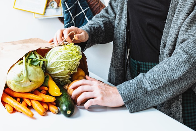 Legumes frescos em sacola ecológica na mesa da cozinha