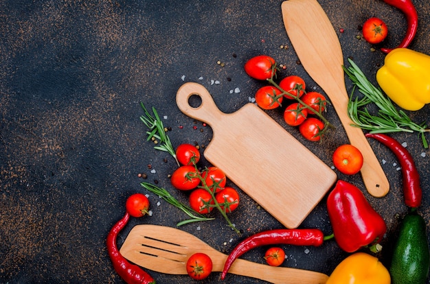 Legumes frescos especiarias ervas ingredientes para uma cozinha saudável ou salada fazendo no fundo escuro e rústico, com espaço para seu texto. vista do topo