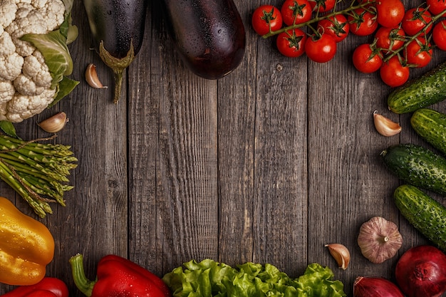 Legumes frescos para cozinhar em fundo escuro de madeira