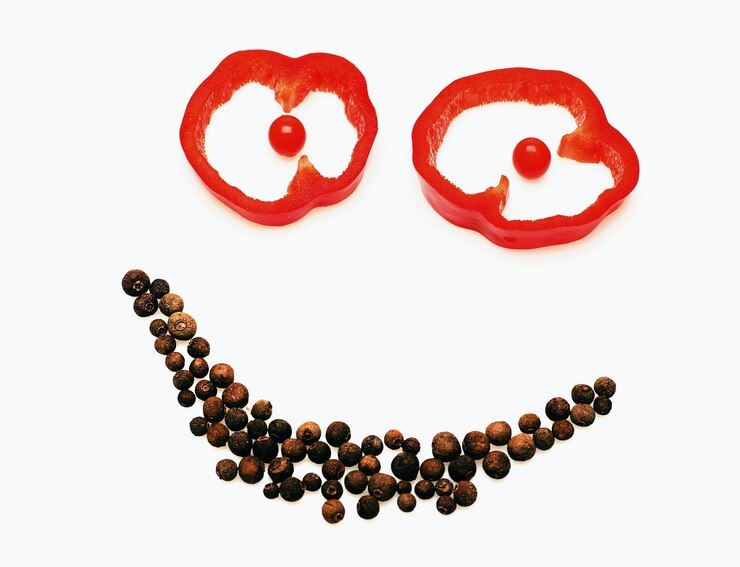 Foto legumes frescos, pimentão, pimenta da jamaica, pimentão, cor vermelha páprica cortada isolada no fundo branco em forma de smiley ou emoticon feliz