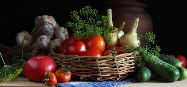 Legumes na mesa tomate maduro pepino alho cebola endro colheita fresca em um fundo escuro