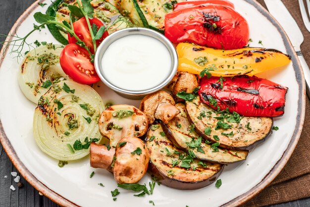 Legumes variados grelhados com molho de alho em um prato