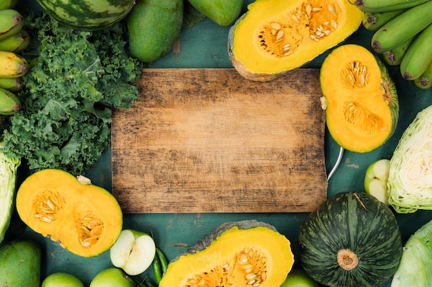 Legumes verdes frescos e frutas em fundo verde de madeira