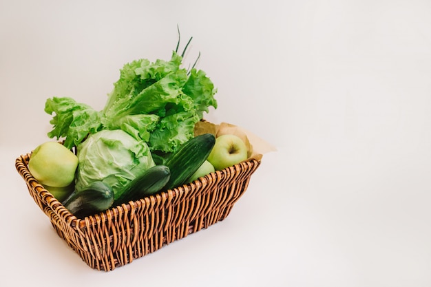Legumes verdes frescos e frutas na cesta