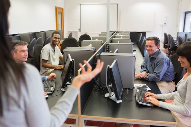 Lehrer, der mit Gruppe im Computerraum spricht