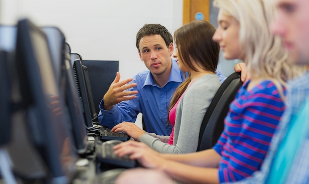 Lehrer, der Studenten im Computerraum erklärt