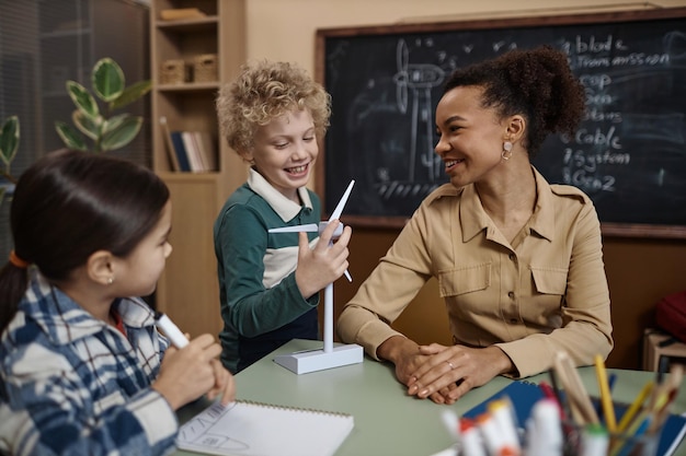 Foto lehrer erklärt den kindern im klassenzimmer umweltfreundliche energie