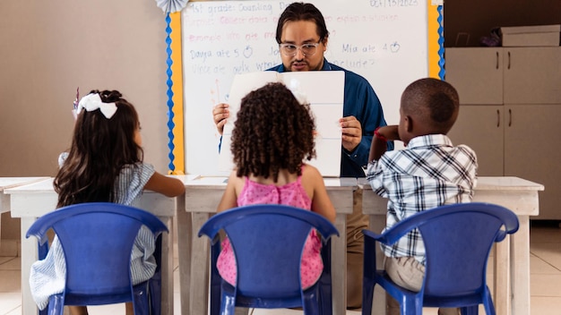 Lehrer, erwachsener Mann, der Kinder in einem Kindergarten unterrichtet