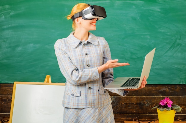 Foto lehrer mit laptop im vr-headset. moderne technologien in der smart school. digitale bildung. lächelnder tutor im klassenzimmer.