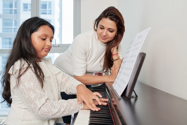 Lehrer mit Schüler, der Klavier spielt