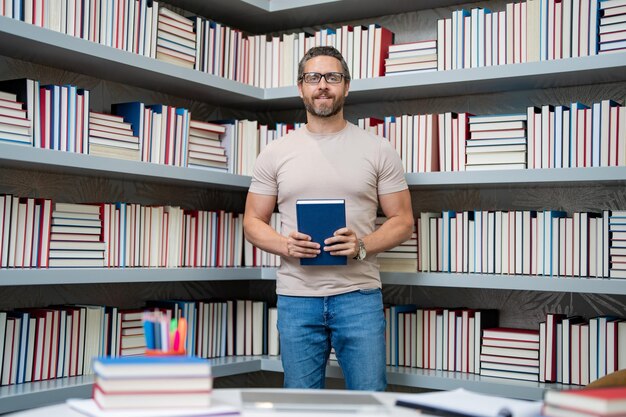 Foto lehrer-nachhilfelehrer im klassenzimmer wissenserziehung mann mit buch unterrichtet unterricht im unterricht