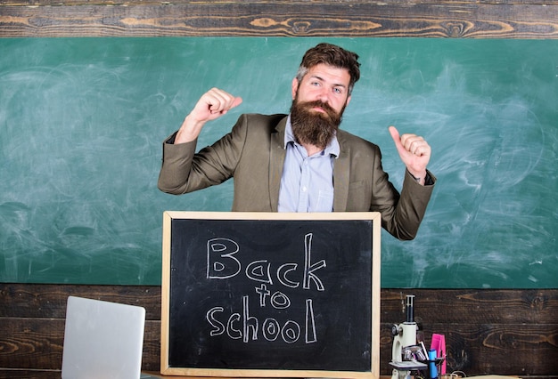 Lehrer oder Erzieher begrüßt die Einschreibung zurück in die Schule. Willkommen zurück in der Schule. Voller Energie nach den Sommerferien