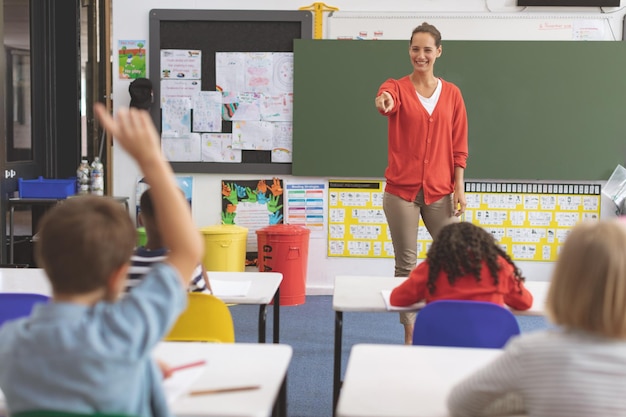 Lehrer stellt einem Schüler im Klassenzimmer eine Frage
