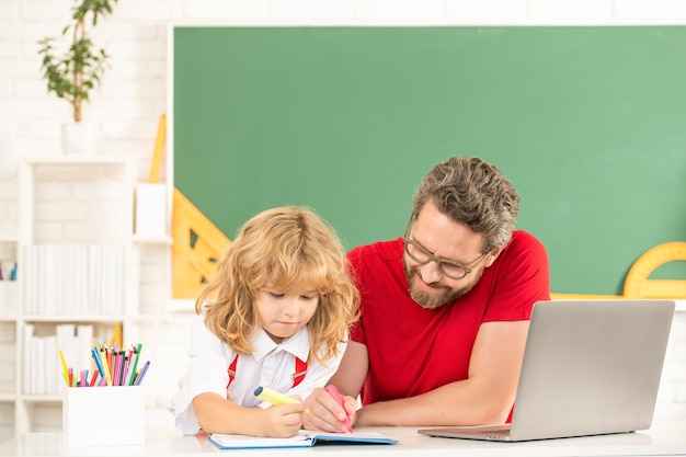 Lehrer und Kind lernen im Klassenzimmer mit Laptop-Vaterschaft