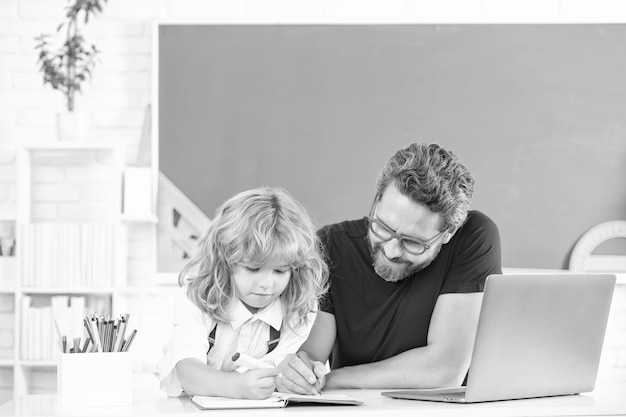 Lehrer und Kind lernen im Klassenzimmer mit Laptop-Vaterschaft