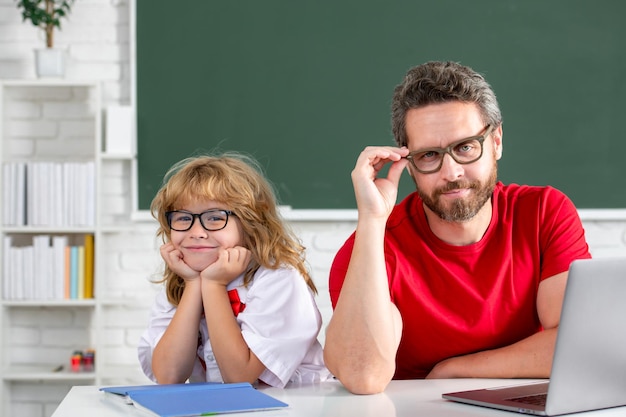 Lehrer und Kind lernen im Schulklassenzimmer lustiger Grundschuljunge