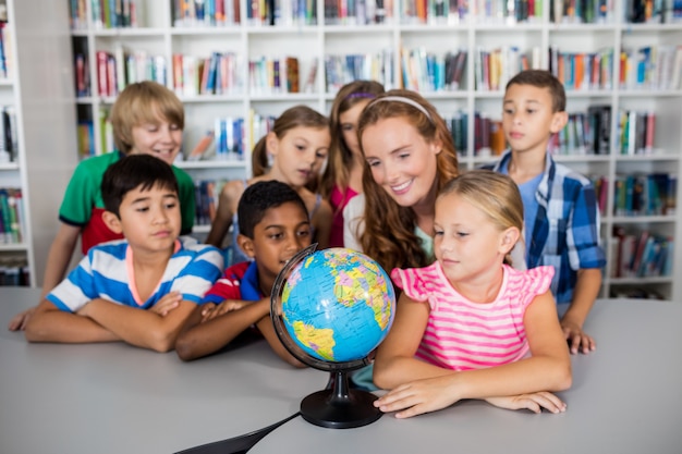 Lehrer und Schüler, die eine Kugel betrachten