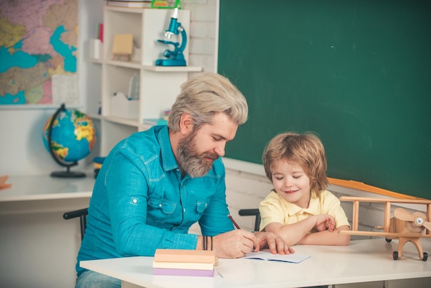 Lehrer und Schüler im Klassenzimmer Kind zu Hause studieren und zu Hause lernen Schüler Bildung Afterschool Nachhilfe Netter Schüler und sein Vater Schularbeit