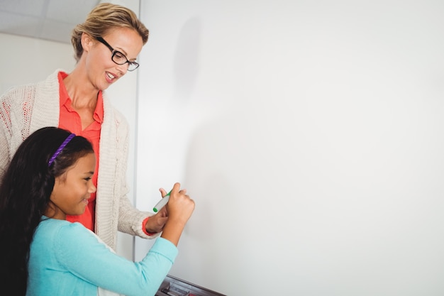 Lehrer und Schüler schreiben auf Whiteboard