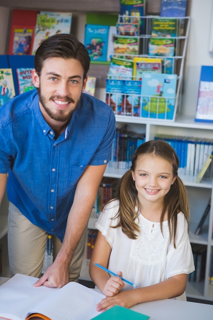 Lehrer und Schulkind lächeln in der Bibliothek