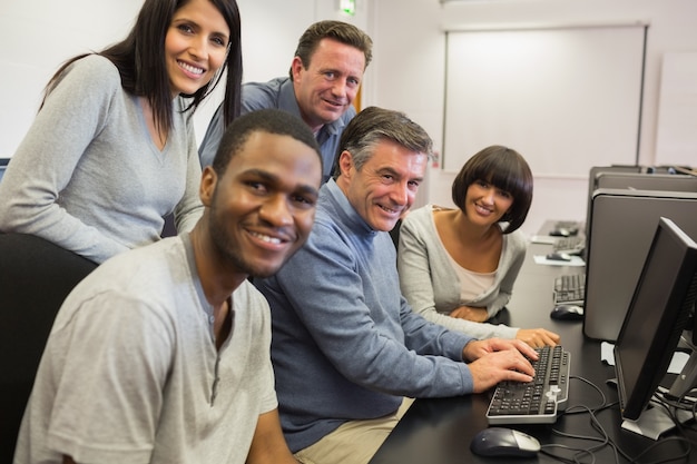 Lehrer und Studenten, die am Computer sitzen