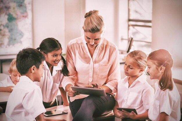 Lehrer unterrichtet Kinder auf digitalem Tablet