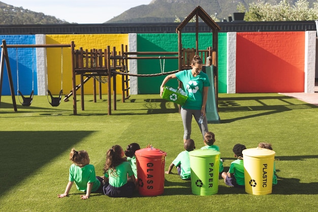 Lehrer unterrichtet über grüne Energie und Recycling auf dem Spielplatz des Schulhofs