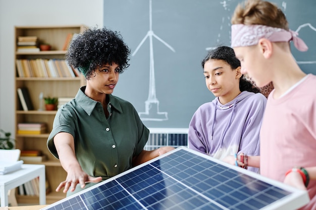 Lehrer zeigt Schülern während des Unterrichts im Klassenzimmer Solarpanel